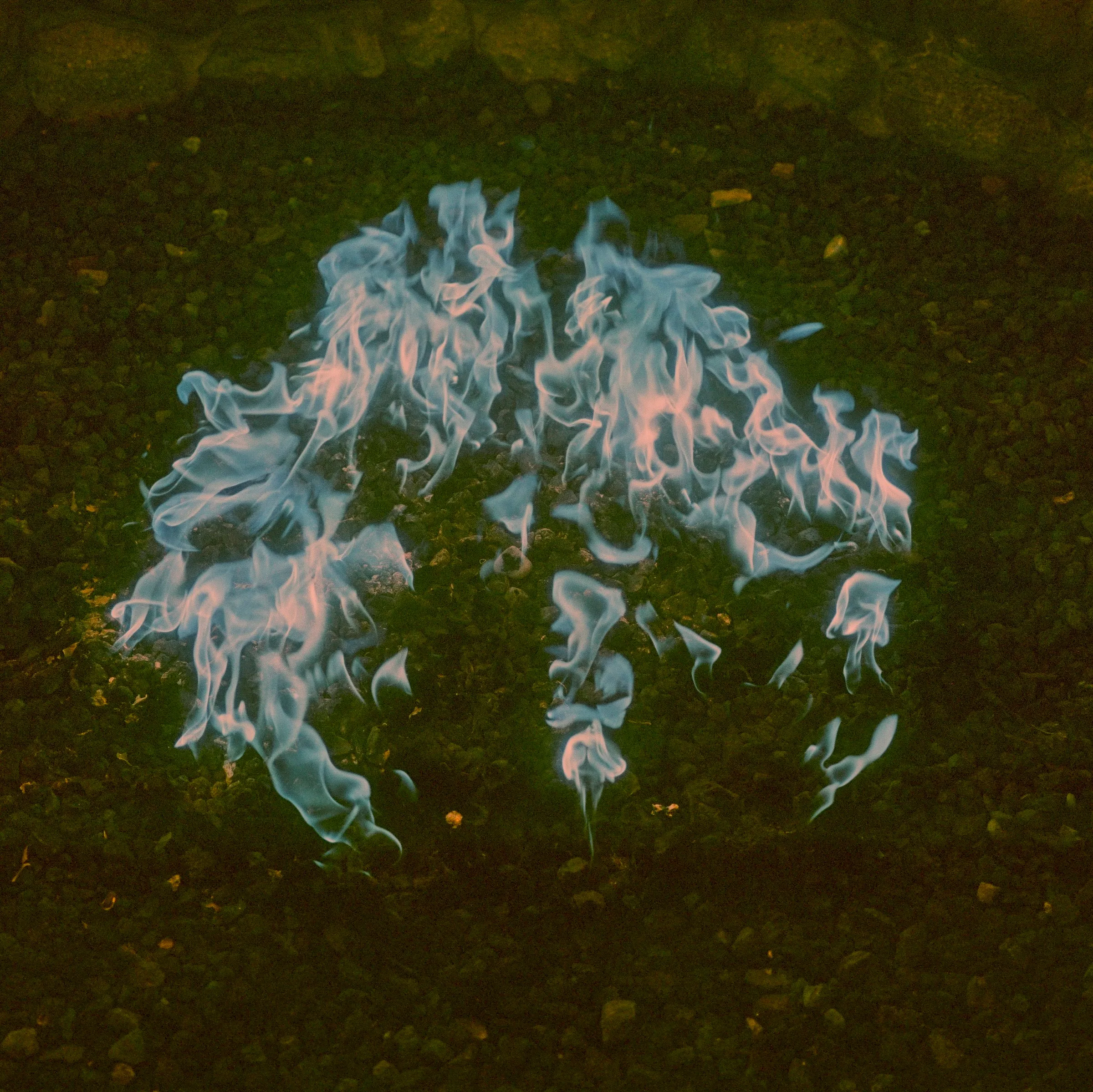 Blue flames spreading across dark ground