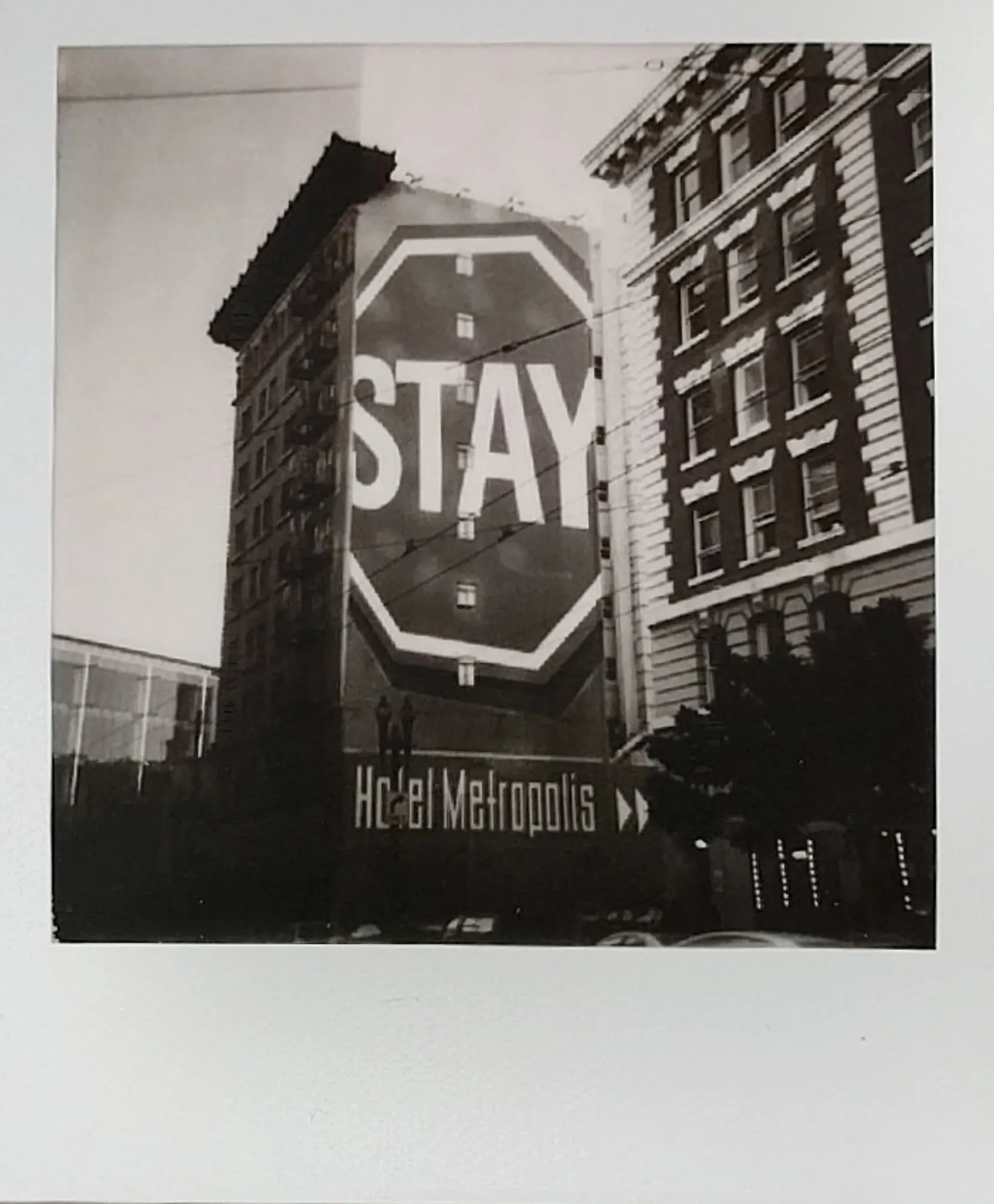 A giant STAY sign painted on the side of the Hotel Metropolis